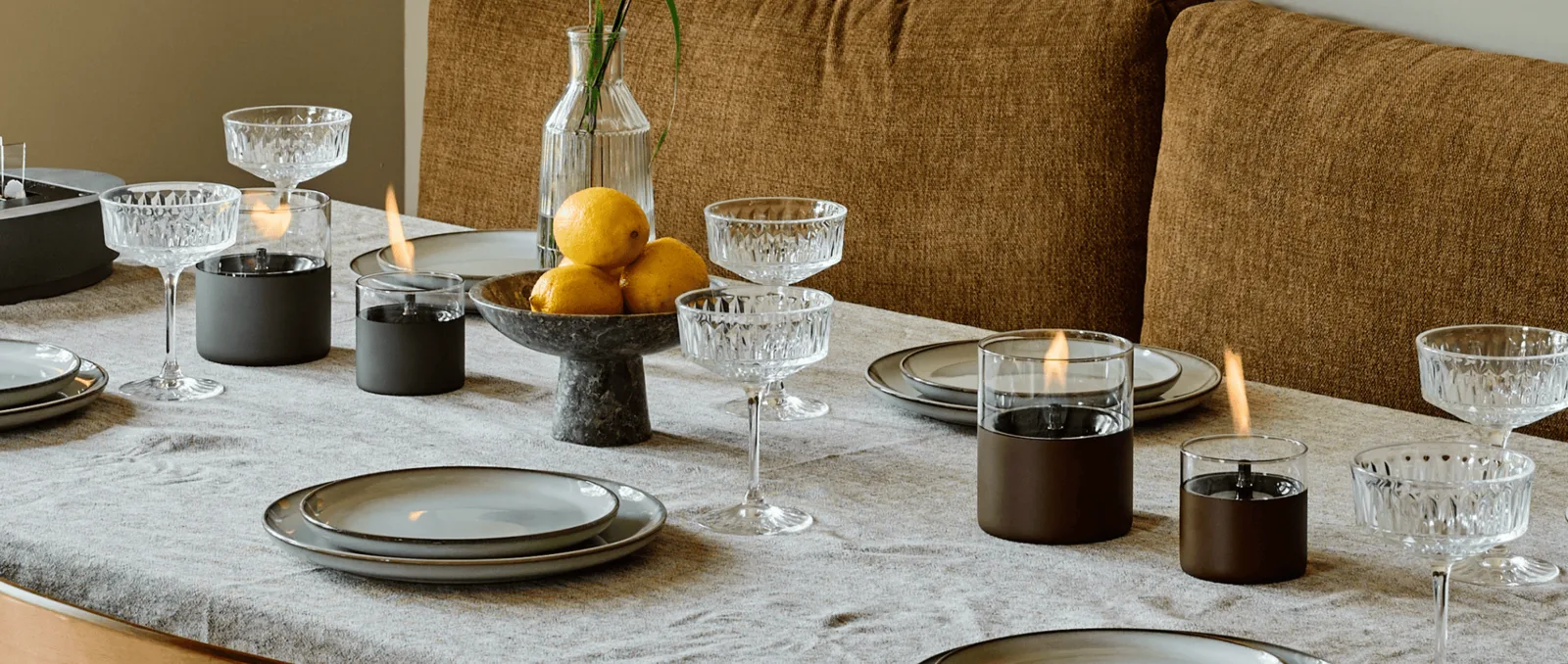 Lit Tenderflame candles on a laid dining table